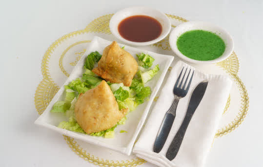 Golden vegetable samosas on a plate