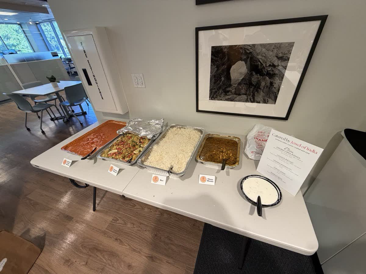 Indian buffet trays set out on a long table for a staff meal